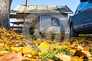 Autumn morning in countryside, small brick house and car in nature background