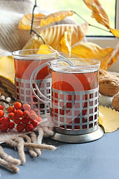 Autumn morning with a Cup of tea. A Cup of tea on a plaid background, surrounded by yellow leaves