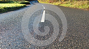 Wet country road in sunshine. Sunny November in the South West of the UK