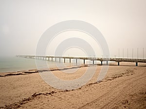 Autumn morning on wooden pier above sea. Depression, dark atmosphere. Touristic mole, wet wooden floor above sea.