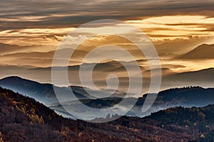 Autumn mountain misty landscape at sunrise. View of the valley from Vrsatec hill, Slovakia.