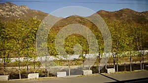 Autumn mountain in rural countryside.Speeding train travel,scenery outside window.