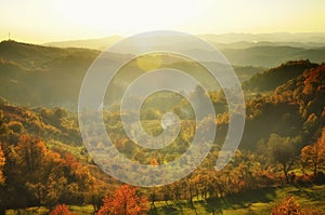 Autumn mountain in the sunset mist. Lens flare effect.