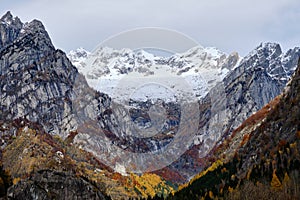 Autumn mountains in Val di Mello, Lombardy: A breathtaking tapestry of vibrant fall foliage adorning the majestic peaks, creating