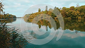 Autumn nature on the shores of the Southern Bug. The calm flow of the river. Reflection in the water of the sky and trees