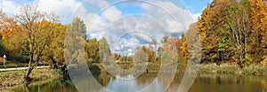 Autumn october sunny day  panoramic European landscape with road  lake and  golden maple forest