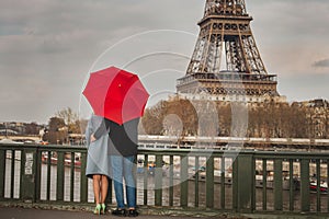 Autumn in Paris, couple under red umbrella near Eiffel tower, fall season, love in rainy day