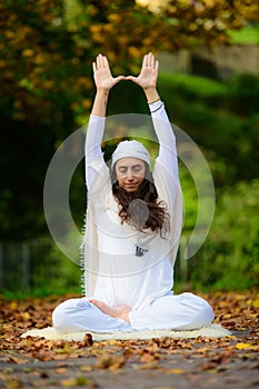 In the autumn park a young woman practices yoga alone photo