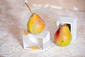 Autumn pear in a white old wooden small box. Life style. Yellow autumn leaves on a concrete light background. Selective focus, spa