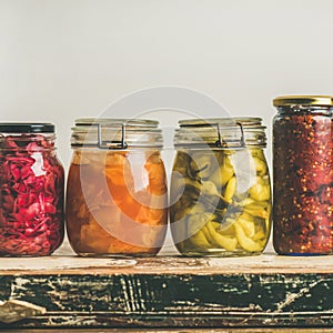 Autumn pickled colorful vegetables in jars placed in row