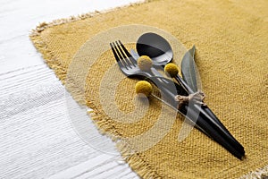 Autumn place setting with cutlery on white table, closeup