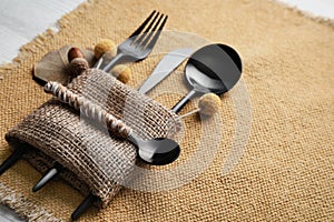 Autumn place setting with cutlery on white table, closeup. Space for text