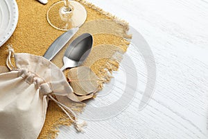 Autumn place setting with cutlery on white wooden table, closeup. Space for text