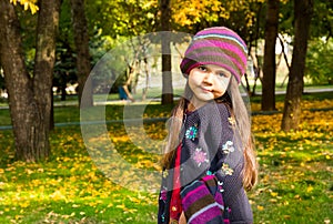 Autumn portrait of beautiful kazakh, asian child. Happy little girl with leaves in the park in fall.