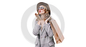 Autumn portrait of beautiful young woman with shopping bags blowing her lips with lipstick wearing coat, round hat  on