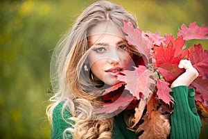 Autumn portrait of cheerful woman with yellow maple leaves. Portrait of beauty girl with autumn leafs on foliage. Close