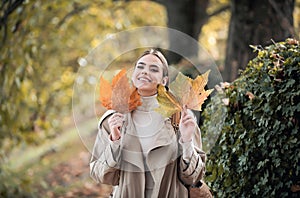 Autumn portrait of cheerful woman with yellow maple leaves. Portrait of beauty girl with autumn leafs on foliage. Close