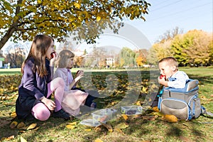 Autumn portrait of children with lunch boxes, school backpacks