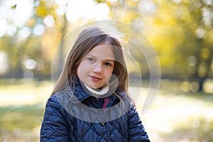 Autumn portrait of cute little blond girl in city park. Beautiful smiling child having fun outdoors on a warm fall day