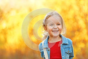 Autumn portrait of a fun little girl. Background in blur