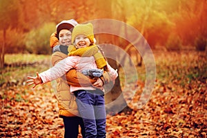 Autumn portrait of happy kids playing outdoor in park.