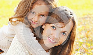 Autumn portrait of happy smiling mother with her daughter child