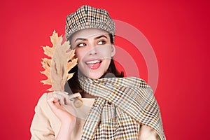Autumn portrait happy smiling woman holding fall maple leaves near face over studio isolated background. Autumn fall