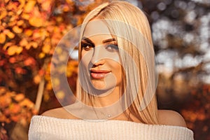 Autumn portrait of Pretty blond girl with makeup and short bob blond hairstyle over yellow leaves