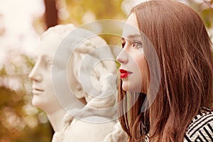 Autumn Portrait of Pretty Woman and Marble Statue Outdoors