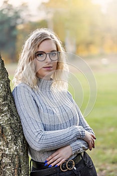 Autumn portrait of serious young woman posing outdoors