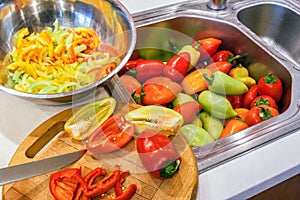 Autumn procuring of crop of peppers. Whole, halved and sliced into lengthwise slices peppers.