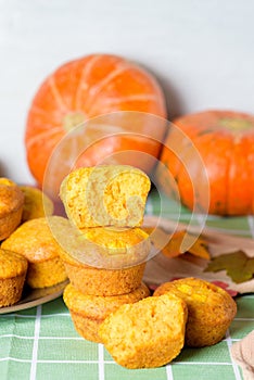 Autumn pumpkin cupcakes with fresh pumpkin for thanksgiving day. autumn composition of pumpkin and maple leaves with baked muffins