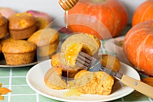 Autumn pumpkin cupcakes with fresh pumpkin for thanksgiving day. autumn composition of pumpkin and maple leaves with baked muffins