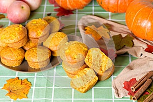 Autumn pumpkin cupcakes with fresh pumpkin for thanksgiving day. autumn composition of pumpkin and maple leaves with pastries