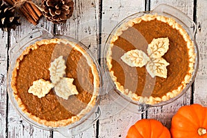 Autumn pumpkin pies with leaf pastry toppings against rustic wood