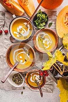 Autumn pumpkin soup puree with cream in cups, the autumn scenery