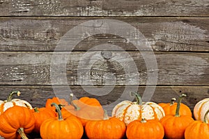 Autumn pumpkins and gourds against old wood background