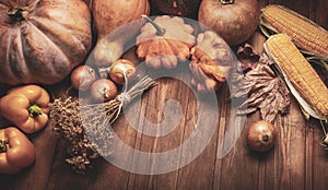 Autumn pumpkins and other fruits and vegetables on wooden thanksgiving table