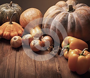 Autumn pumpkins and other fruits and vegetables on wooden thanksgiving table