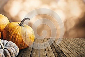 Autumn pumpkins still life on vintage wooden table and bokeh background. Thanksgiving family dinner greeting card design.