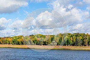 Autumn river landscape. Picturesque clouds. Yellowing leaves on trees