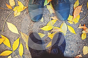 Autumn romance. Legs of man and woman on fallen leaves