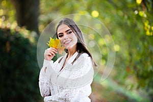 Autumn romance woman with leaves. Female model on foliage day. Dream and lifestyle. Beauty outdoor portrait. Carefree