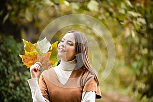 Autumn romance woman with leaves. Female model on foliage day. Dream and lifestyle. Beauty outdoor portrait. Carefree