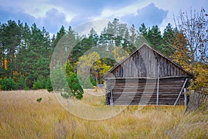 Autumn rural landscape with fence, field, forest and house