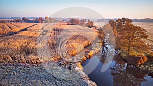 Autumn rural landscape. Frost on grass. River, Corn field, meadow, village, fall color trees