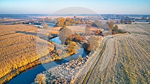 Autumn rural landscape. Frost on grass. River, Corn field, meadow, village, fall color trees