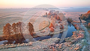 Autumn rural landscape. Frost on grass. River, field, meadow, fall color trees. Sunrise morning aerial panorama