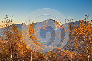 Autumn rural landscape with mountains peaks on background