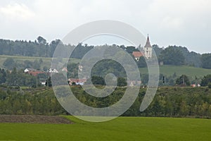 Misty farming scene with village in distance on an overcast day photo